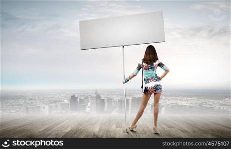 Woman with banner. Rear view of young attractive woman with blank white banner