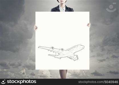 Woman with banner. Unrecognizable woman showing white banner with airplane design