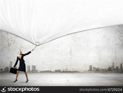 Woman with banner. Young businesswoman pulling white banner with lead