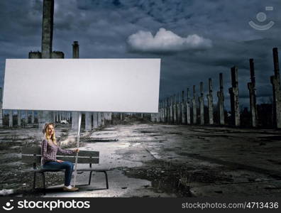 Woman with banner. Young girl in casual with white banner sitting on bench. Place for text