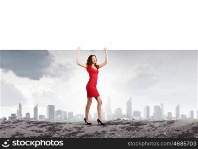 Woman with banner. Young woman in red dress holding white blank banner