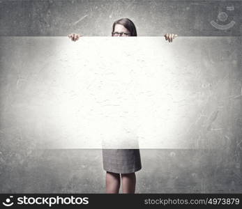 Woman with banner. Young woman showing blank concrete textured banner. Place for text