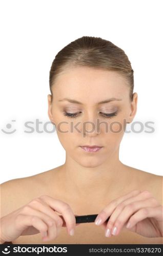 Woman with bare shoulders looking at a lipstick