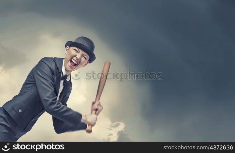 Woman with baseball bat. Young emotional woman in suit and hat with baseball bat