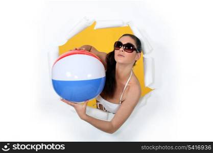 Woman with beach ball coming out of hole