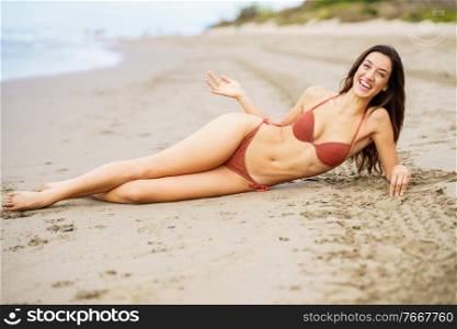 Woman with beautiful body laughing on a tropical beach wearing red bikini. Woman with beautiful body laughing on a tropical beach wearing bikini