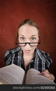 Woman with big eyes and glasses reading a book.