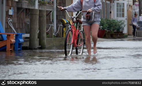 Woman with bike in a flood