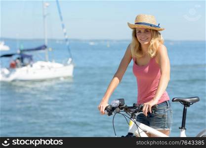 woman with bike on the beach