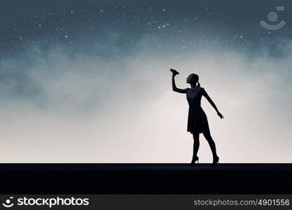 Woman with binoculars. Silhouette of woman at night looking in binoculars