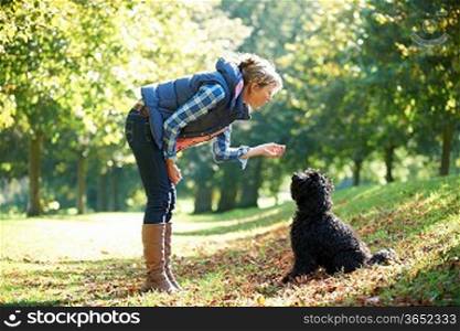 woman with black dog on a walk in the park