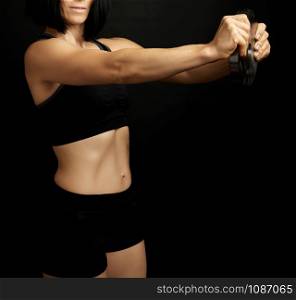 woman with black hair and a sports figure holds a steel circle for sports, low key