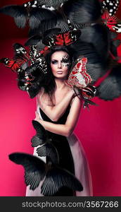 Woman with black hair and art make up and red butterflies