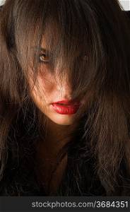 woman with black hair on face and red eyes looking anger in camera