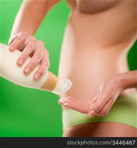 Woman with body lotion slim silhouette on green background