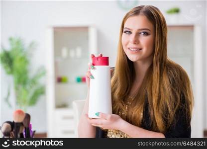 Woman with bottle of cream in make-up concept