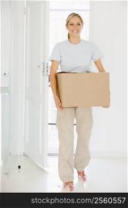 Woman with box moving into new home smiling