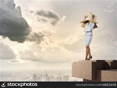 Woman with box on head. Businesswoman standing on top of building with carton box on head