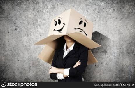 Woman with box on head. Businesswoman wearing carton box with drawn smiley on head