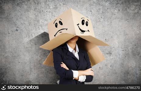 Woman with box on head. Businesswoman wearing carton box with drawn smiley on head
