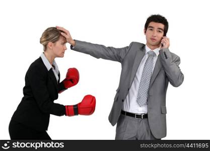 Woman with boxing gloves trying to hit woman