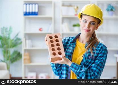 Woman with brick in construction concept