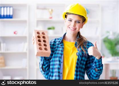 Woman with brick in construction concept. The woman with brick in construction concept