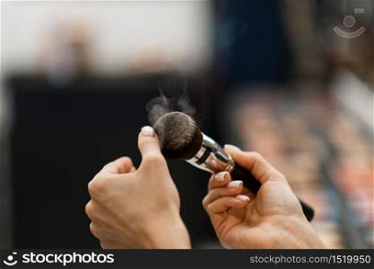 Woman with brush, dust in motion, cosmetics store. Buyer in luxury beauty shop salon, female customer in fashion market. Woman with brush, dust in motion, cosmetics store