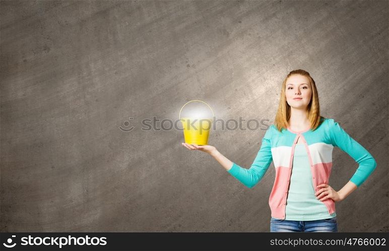 Woman with bucket. Young woman in casual with yellow bucket in hands