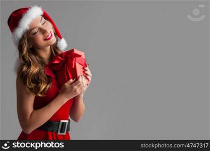 Woman with Christmas gift. Beautiful hispanic woman in red santa claus costume holding Christmas gift