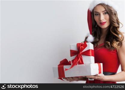 Woman with Christmas gifts. Beautiful hispanic woman in red santa claus costume holding Christmas gifts