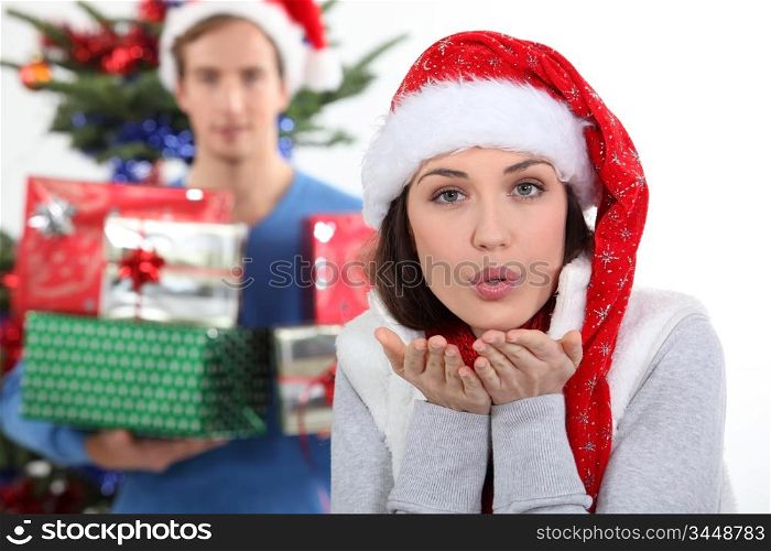 Woman with Christmas hat blowing kiss