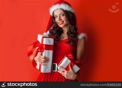 Woman with Christmas presents. Excited surprised woman in red santa claus outfit holding Christmas presents