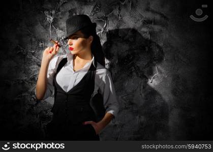 Woman with cigar on grey wall background