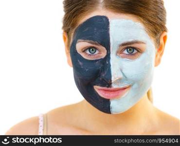 Woman with clay carbo black mask on half face and white mud on second half. Girl taking care of oily complexion. Beauty procedures. Skincare.. Girl with black white mud mask on face