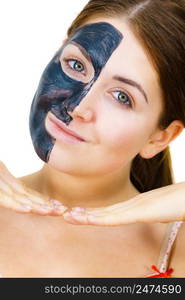 Woman with clay carbo detox black mask on her face, on white. Girl taking care of oily skin complexion. Beauty treatment. Skincare.. Woman with black carbo mask on face