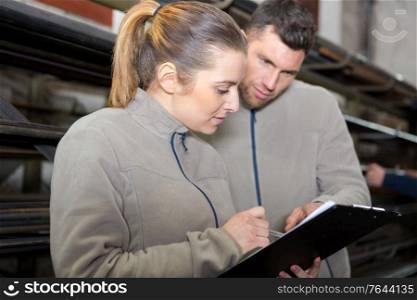 woman with clipboard standing back at warehouse
