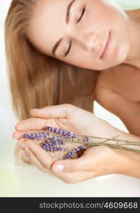 Woman with closed eyes at spa salon, holding lavender and sea salt, enjoying aromatherapy herbal anti-stress treatment for health of mind and soul, body skin face and hair care, selective focus&#xA;