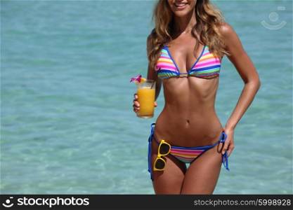 Woman with cocktail on beach. Beautiful woman in bikini with cocktail on beach