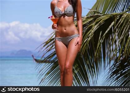 Woman with cocktail on beach. Beautiful woman with cocktail posing on tropical beach