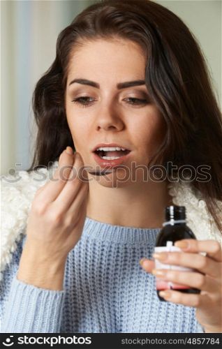 Woman With Cold Taking Medicine On Spoon