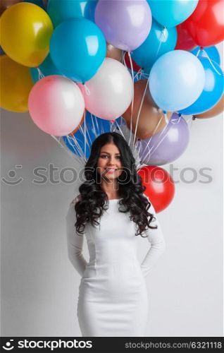 Woman with colorful balloons. Cheerful woman holding many colorful balloons, celebration and happiness concept