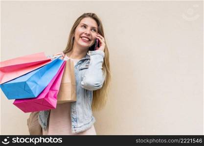 woman with colourful shopping bags talking by phone