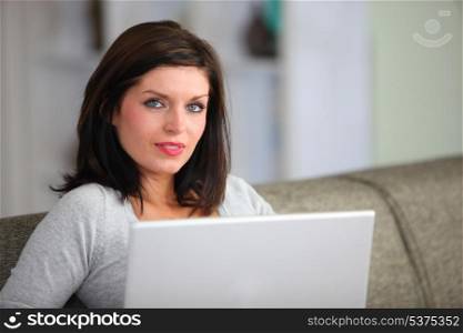 Woman with computer sitting on sofa