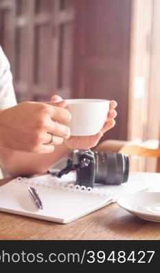 Woman with cup of coffee in coffee shop, stock photo