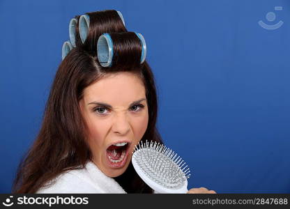 woman with curlers in her hair singing