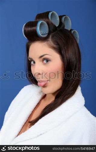 Woman with curlers sticking out his tongue