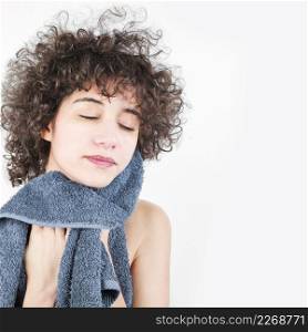 woman with curly hair wiping her face with towel isolated white background