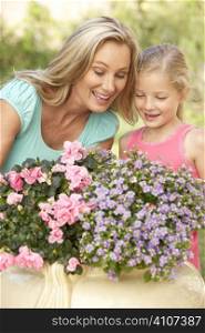 Woman With Daughter Gardening Together