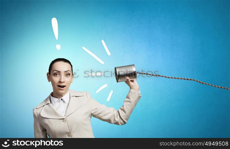 Woman with deaf phone. Young pretty businesswoman attaching tin phone to ear
